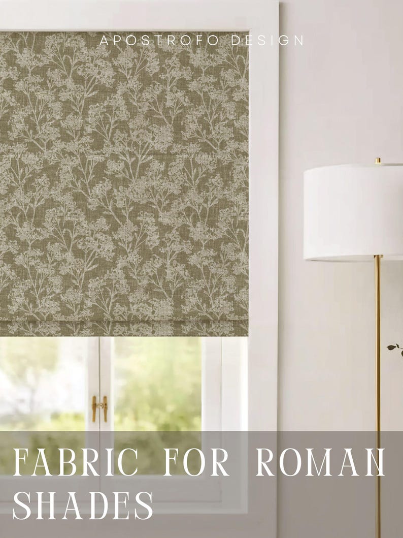 May include: A Roman shade featuring a dark olive green fabric with a white botanical print of delicate wildflowers and stems. The text APOSTROFO DESIGN is visible at the top, and the text FABRIC FOR ROMAN SHADES is visible at the bottom.