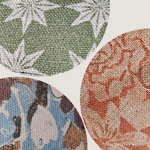 May include: Three circular fabric swatches labelled FABRICS TEXTURES and APOSTROFO DESIGN. The top swatch is green with white star patterns. The bottom left swatch features blue, brown, and white floral motifs. The right swatch is orange with floral patterns.