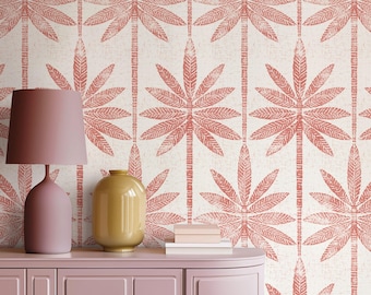 May include: A pink sideboard with a matching pink table lamp, a yellow vase, and stacked books against a wallpaper featuring a repeating pattern of coral-colored palm trees on a textured off-white background with the text APOSTROFO DESIGN.