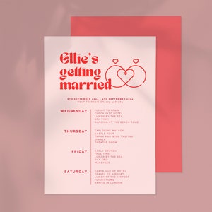 Puede incluir: Una invitaci&oacute;n de boda rosa y roja con el texto "Ellie's getting married" y un itinerario de boda para una boda en Espa&ntilde;a. El itinerario incluye actividades como un vuelo a Espa&ntilde;a, una visita al castillo y una excursi&oacute;n de un d&iacute;a a la playa.