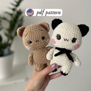 May include: Two crocheted teddy bears. One is light brown, the other is white with black ears and a black bow. Both have black eyes, pink cheeks, and a stitched mouth. The text "pdf pattern" is above the bears.