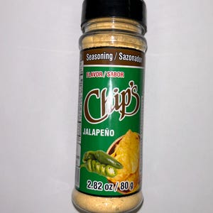 May include: A clear plastic bottle of jalape&ntilde;o seasoning with a black lid. The label features the text "Chips Jalape&ntilde;o" and a graphic of a jalape&ntilde;o pepper and chips. The bottle contains 80 g of seasoning.