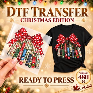 Peut inclure: Un t-shirt noir et une feuille de transfert DTF transparente présentant tous deux un motif de grand nœud rouge à pois blancs avec des ornements suspendus en forme de cassettes VHS de films de Noël comme Rudolph, Elf et Home Alone.