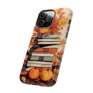 May include: A phone case with a fall-themed design featuring a stack of books, pumpkins, and autumn leaves. The case is designed for an iPhone with a camera bump.