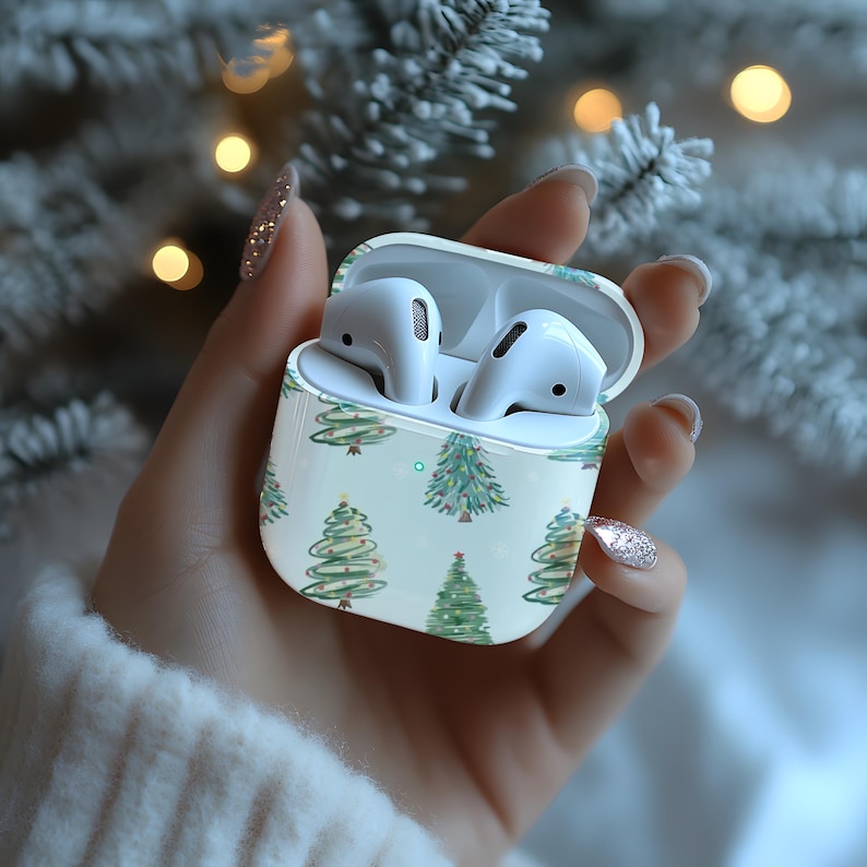 K&ouml;nnte beinhalten: Wei&szlig;es drahtloses Ohrh&ouml;rer-Etui mit einem Weihnachtsbaum-Muster. Das Etui ist ge&ouml;ffnet und die Ohrh&ouml;rer befinden sich darin.