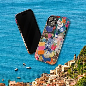May include: Two phone cases, one black and one with a colorful collage of images, including a blue eye, a red heart, and a yellow star. The text "Love your favorite things" is visible on the colorful case.