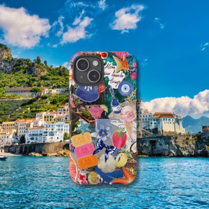 May include: A colorful phone case with a collage of images, including a fish, a cocktail, a strawberry, and the text "Move your favorite things".
