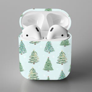 K&ouml;nnte beinhalten: Ein wei&szlig;es Airpods-Case mit hellblauem Hintergrund und einem sich wiederholenden Muster aus gr&uuml;nen Weihnachtsb&auml;umen.