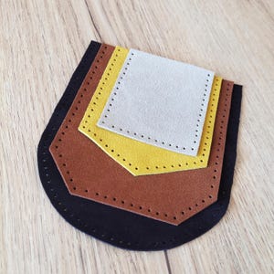May include: A layered set of leather bag bases in black, brown, yellow, and gray. Each piece has pre-punched holes for stitching. The pieces are arranged in a nested pattern, with the black base at the bottom and the gray square at the top.