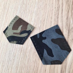 May include: Two hexagonal patches with a camouflage pattern. One patch features shades of green, brown, and black. The other patch has a blue, gray, and black camouflage design. Both patches have small holes around the edges.