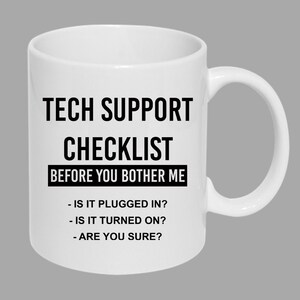 May include: White ceramic mug with black text that reads "Tech Support Checklist Before You Bother Me" and a list of questions: "Is it plugged in? Is it turned on? Are you sure?"