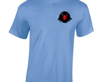 Puede incluir: Una camiseta azul claro con un gráfico de disco de vinilo negro. El disco se está derritiendo y goteando líquido negro. El disco tiene una etiqueta roja.