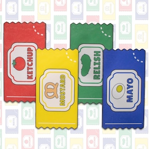 May include: Four colorful condiment packets: red ketchup, yellow mustard, green relish, and blue mayo. Each packet has a white label with the condiment's name and a corresponding graphic: tomato, pretzel, pickle, and egg. The background features a repeating pattern of the same packets.