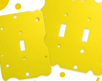 May include: Four yellow light switch covers with a cheese-like design. The covers have different sizes and are available in four sizes.