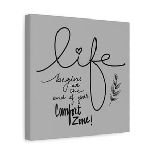 May include: A gray canvas print with black text that reads "life begins at the end of your comfort zone!" with a small heart and a stylized leaf design.