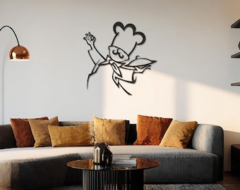 May include: Black metal wall art depicting a chef holding a platter, with a chef's hat and a mustache. The art is mounted on a white wall above a gray sofa with orange and yellow throw pillows. A modern living room setting.