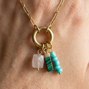 May include: A white ceramic mug with a black handle and the text "But first, coffee" in a black, handwritten-style font. The mug is on a white surface.