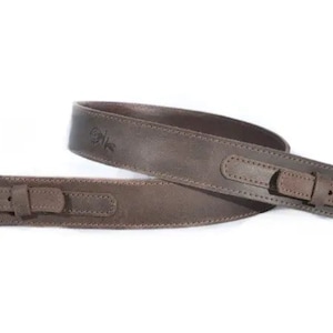 May include: A brown leather camera strap with a stitched design and a small logo embossed on the strap.
