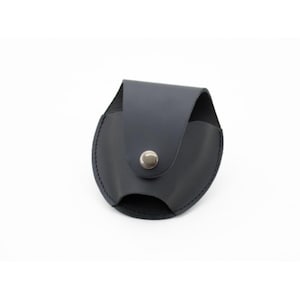 May include: Black leather handcuff case with a snap closure.