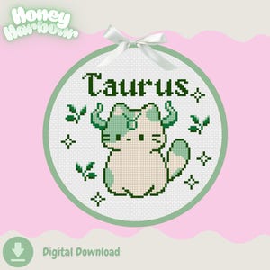Peut inclure: Un motif de point de croix circulaire représentant un chat blanc avec des taches et des cornes vertes, portant l'inscription Taurus en vert foncé. Le design inclut de petites feuilles et des étoiles, avec un ruban blanc sur le dessus.