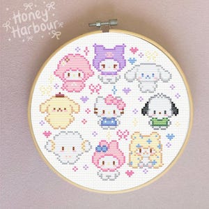 May include: A cross-stitch embroidery hoop featuring various cartoon characters in pastel colors. The characters include a pink bear, a purple cat, a white dog, a yellow dog, a white sheep, a pink cat, a blue cat, and a yellow bear. The text "Honey Harbour" is in the upper left corner.