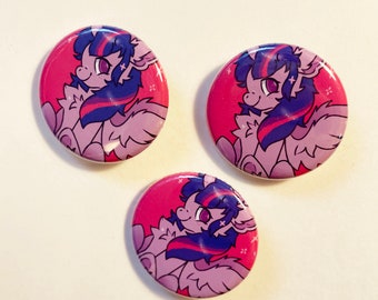 May include: Three round buttons featuring a cartoon pony with purple, pink, and blue colors. The pony has a pink background with a star design. The buttons are arranged in a triangular pattern.