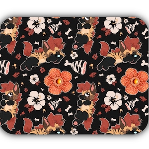 May include: A black mouse mat with a repeating pattern of cartoon hyenas with orange fur, red flowers, and white hibiscus flowers. The hyenas are wearing black and white striped collars.