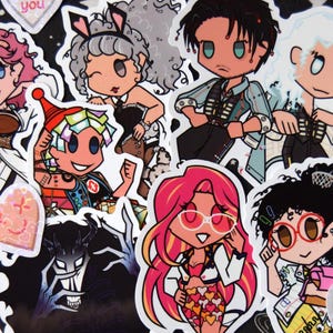 May include: A selection of vibrant stickers showcasing cartoon characters in diverse attire and hairstyles. Some stickers feature heart shapes with phrases such as "Boo to you" and "Scare me". The backdrop is black, adorned with a pattern of stars and planets.