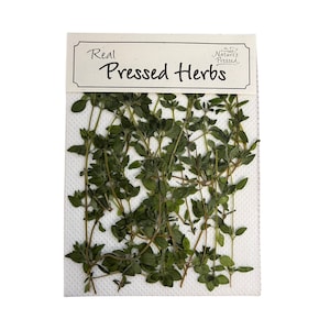 May include: A pack of real pressed herbs, labelled "Real Pressed Herbs" with a small logo that says "Nature's Pressed". The herbs are green and arranged on a white background.
