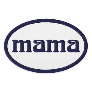 Könnte beinhalten: Ein weißer ovaler Patch mit einem dunkelblauen Rand und dem Wort "mama" in dunkelblau gestickt.