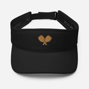 May include: Black visor with a brown embroidered design of two crossed tennis rackets.