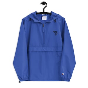 May include: Royal blue Champion windbreaker jacket with a black fish logo on the chest. The jacket has a hood, a half-zip closure, and a front pocket. The Champion logo is on the left sleeve.