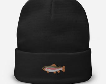 Puede incluir: Gorro negro con un diseño de trucha bordada. El pez presenta detalles en naranja, rojo y plateado, añadiendo un toque de color sobre el fondo oscuro. Un accesorio elegante y práctico para los amantes de las actividades al aire libre.