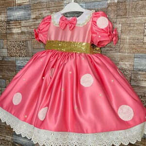 Pink outfit with dots for birthday girl. Photo session for a girl dressed in a themed dress. birthday with pink dress and white dots