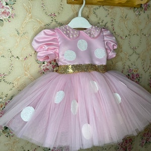 Pink outfit with dots for birthday girl. Photo session for a girl dressed in a themed dress. birthday with pink dress and white dots