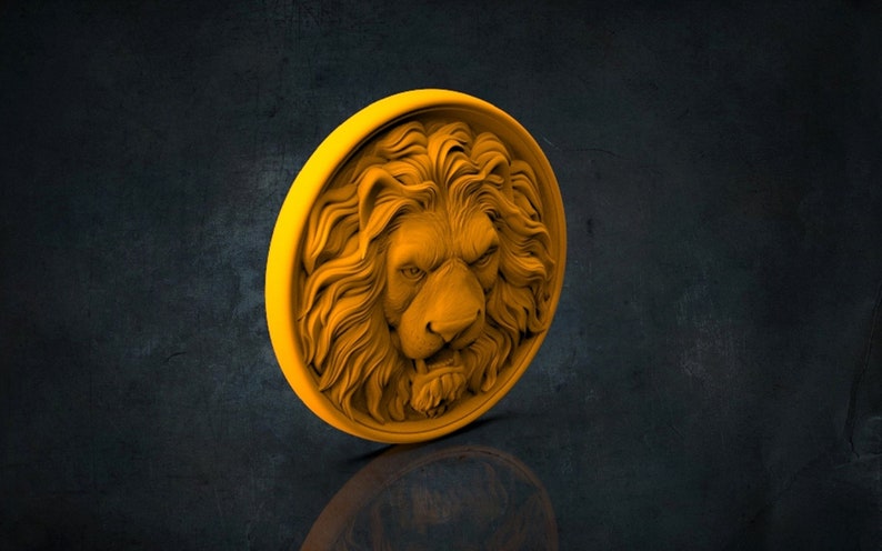 Op de afbeelding: Een gouden leeuwenkop sculptuur met een gedetailleerde manen en een woeste uitdrukking. Het beeld is rond en heeft een verhoogde rand.