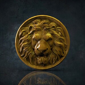 Op de afbeelding: Een gouden leeuwenkop sculptuur gesneden uit hout. De leeuwenmanen is gedetailleerd en het beeld is rond.