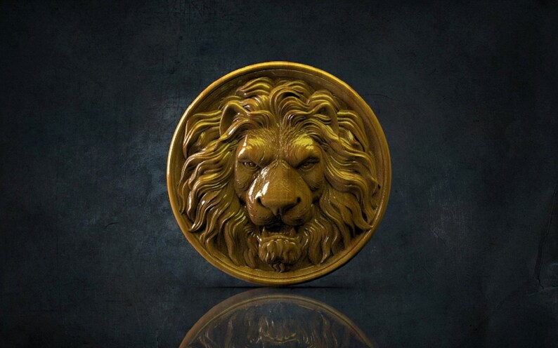 Op de afbeelding: Een gouden leeuwenkop sculptuur gesneden uit hout. De leeuwenmanen is gedetailleerd en het beeld is rond.