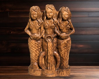 May include: A wooden sculpture of three figures, each holding a bowl, with a water fountain flowing from the center. The figures are carved in a detailed style, with flowing hair and intricate clothing.