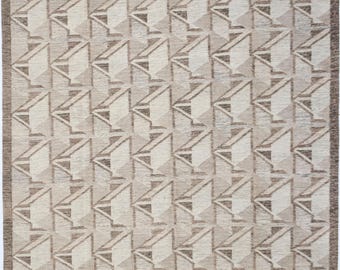 May include: A beige and brown geometric patterned rug with a repeating pattern of triangles. The rug has a subtle gradient effect, with the beige color becoming more prominent towards the bottom.