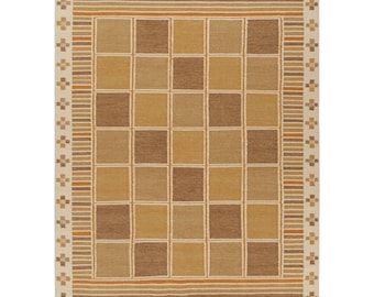 May include: A rectangular area rug with a geometric pattern. The rug features a grid of squares in shades of brown and tan, framed by a border with stripes and cross-shaped designs. The rug's design is symmetrical and has a neutral color palette.