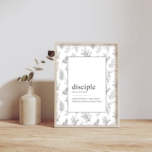 Könnte beinhalten: Schwarz-weiß druckbarer Kunstdruck mit floralem Hintergrundmuster. Der Druck zeigt das Wort "Jünger" mit seiner Definition: "ein Schüler oder Lernender, ein Name, der verwendet wird, um alle Nachfolger Jesu Christi zu bezeichnen."