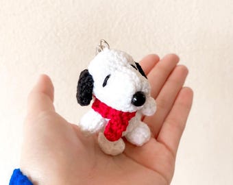 May include: White crocheted dog keyring with black eyes and a red scarf.