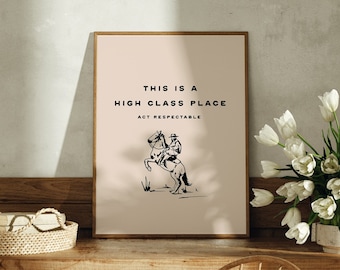 Puede incluir: Una impresión enmarcada con un fondo beige y texto negro que dice "This is a High Class Place Act Respectable". Una ilustración en blanco y negro de un vaquero montando un caballo está en el centro de la impresión.
