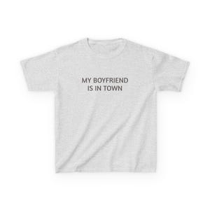 Puede incluir: Camiseta gris claro con el texto "MY BOYFRIEND IS IN TOWN" en gris oscuro. La camiseta tiene cuello redondo, mangas cortas y está hecha de un tejido suave.
