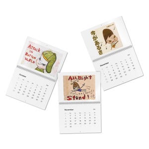 Puede incluir: Tres calendarios abiertos con espiral con ilustraciones y texto. Los calendarios son para octubre, noviembre y diciembre de 2020. El calendario de octubre tiene el texto "ATTACK THE ROTTEN WORLD". El calendario de noviembre tiene el texto "All Night". El calendario de diciembre tiene texto japonés.