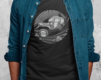 May include: A black t-shirt with a gray graphic of a jeep driving through a rocky landscape. The jeep has the word "Renegade" printed on the side.