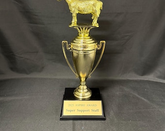 May include: A gold-colored trophy with a goat figurine on top. The trophy has a cup-like body with handles and a black base. The base has a gold plaque that reads "2025 ASPIRE AWARD Super Support Staff."