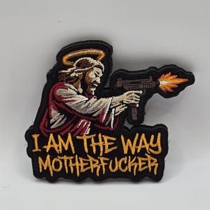 May include: Embroidered patch featuring a depiction of Jesus holding a machine gun with flames. The patch has a black border and the text "I AM THE WAY MOTHERFUCKER" in yellow.