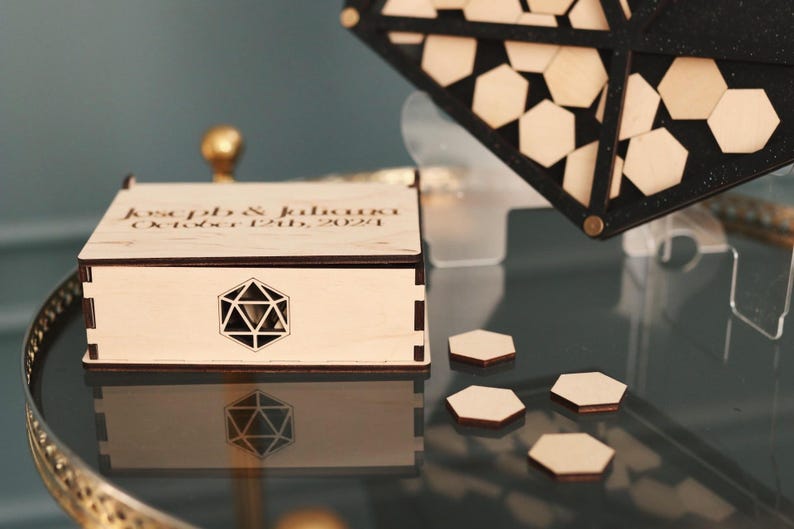 May include: A wooden box with a geometric design on the lid. The box is engraved with the text "Katelyn & Jalouri October 12th, 2021".